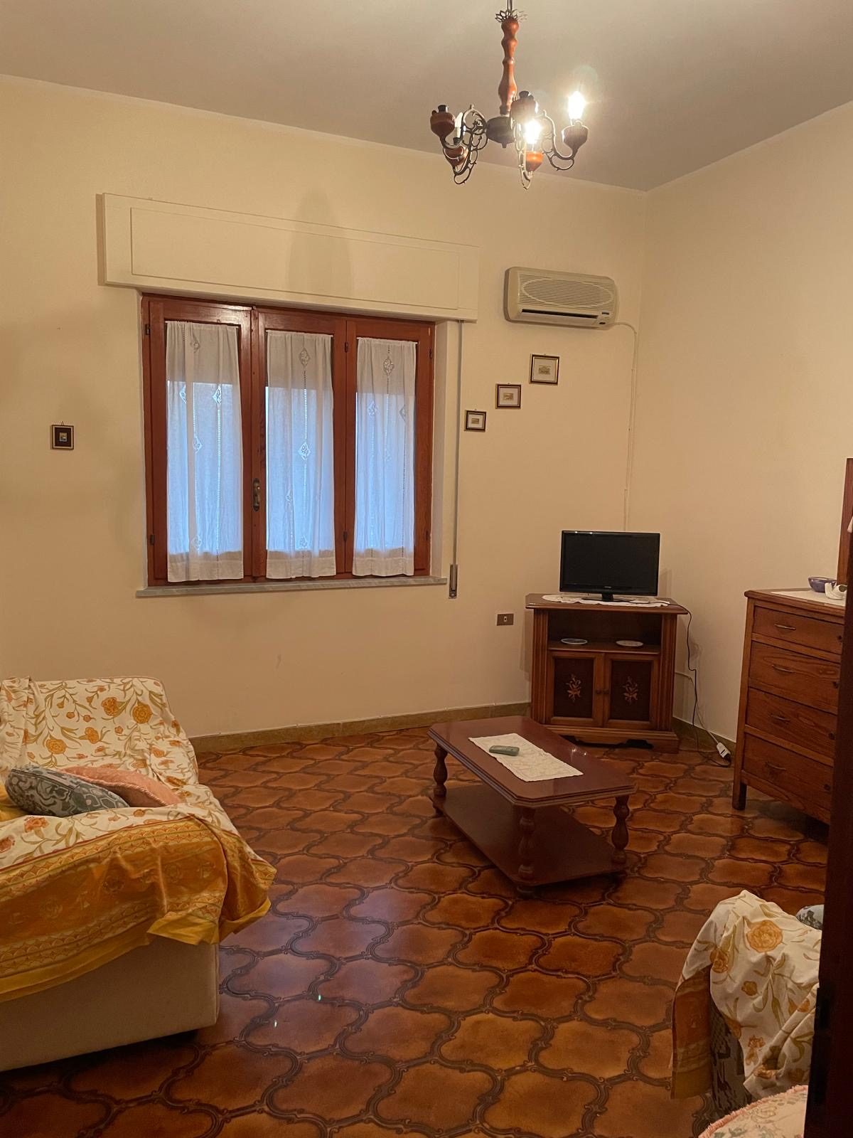 Soggiorno con finestra, tende e climatizzatore nell'appartamento da 160 mq di Casa Morello